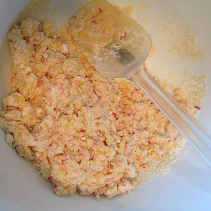 A spatula sits in a bowl with cake mix, oil and an egg.
